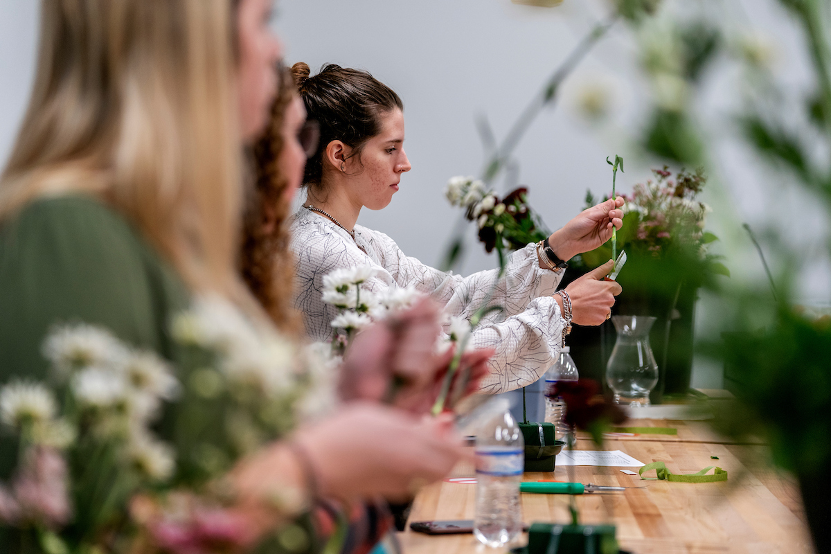 Students working on floral design at a table