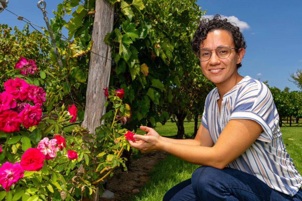Christiane Hayumi Taniguti, Ph.D, crouched next to flowers