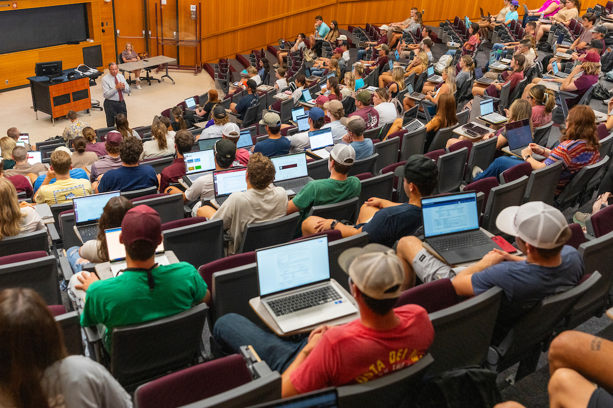 Students sitting in a lecture hall listening to a professor